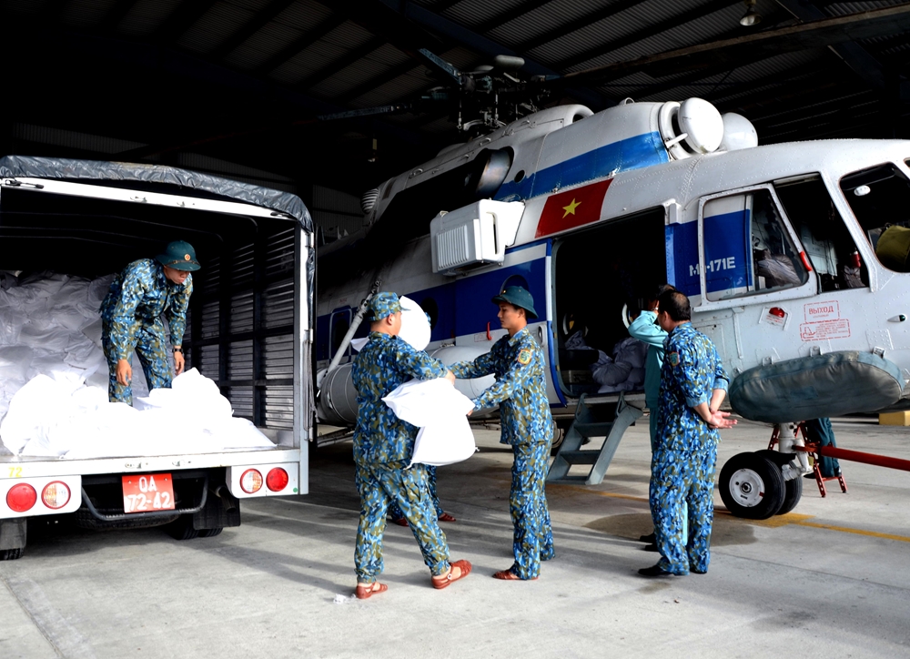 Vận chuyển hàng sang máy bay trực thăng để chuẩn bị bay cứu trợ đồng bào vùng lũ Phước Sơn.